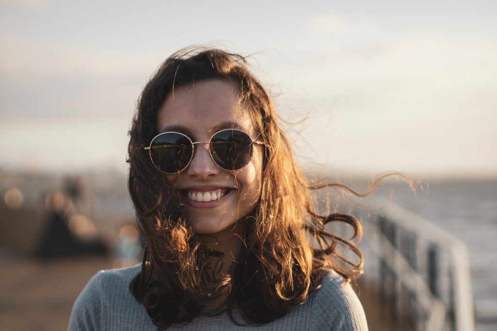 woman in blue sweater wearing black sunglasses
