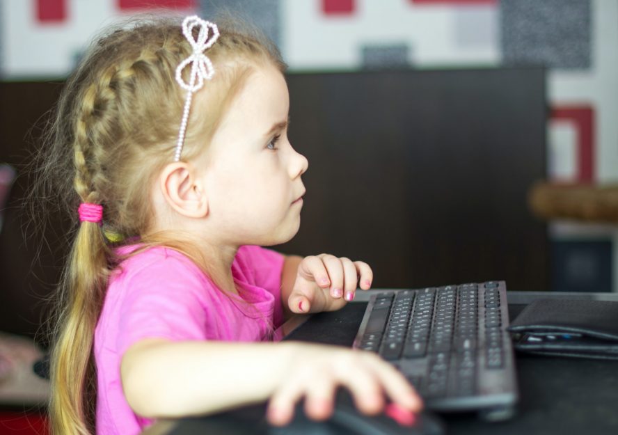 girl in pink shirt using black laptop computer
