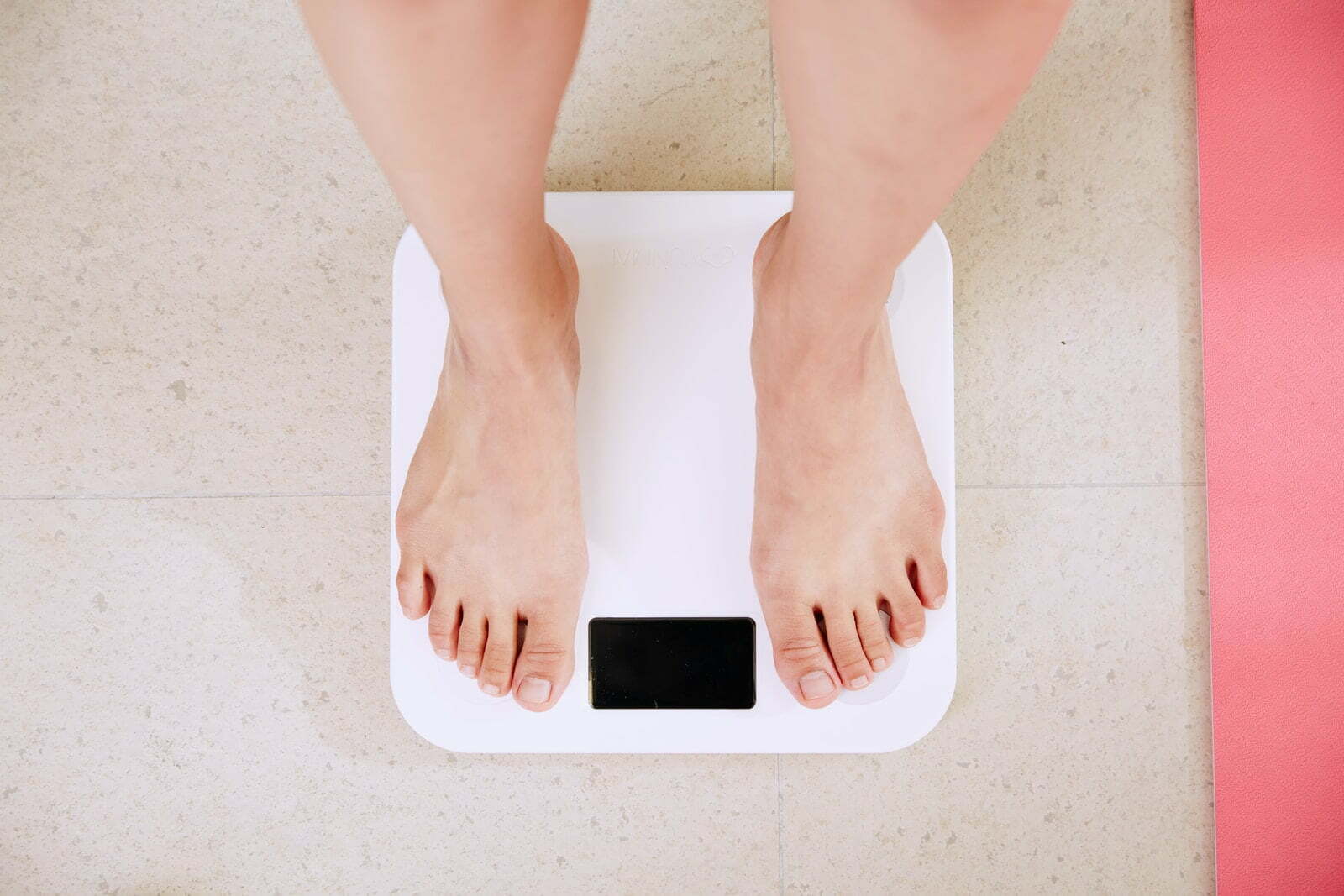 Benefits of attending a weight loss clinic person standing on white digital bathroom scale