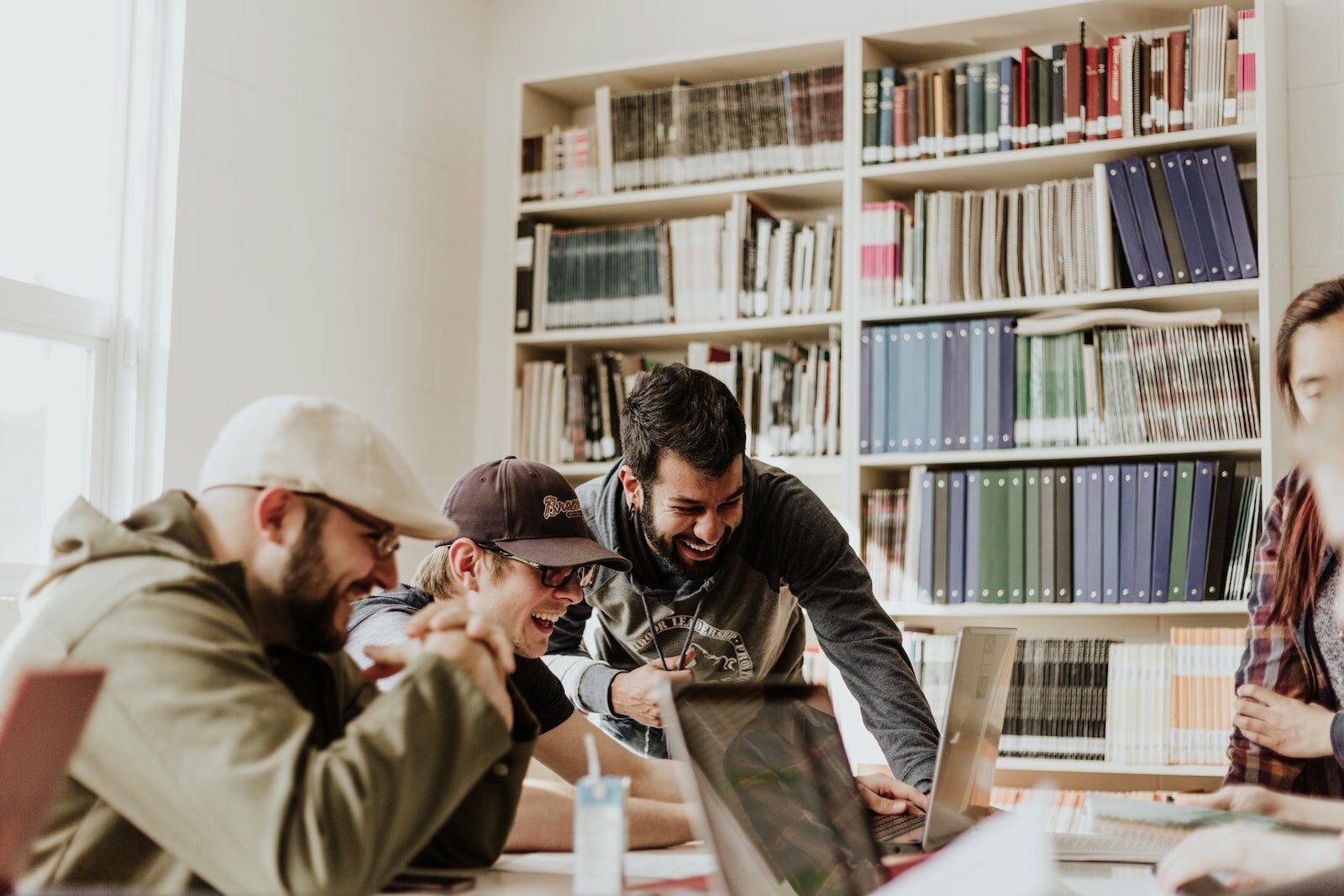 5 Reasons Why Outsourcing Is a Must for Sydney-Based SaaS Start-ups three men laughing while looking in the laptop inside room