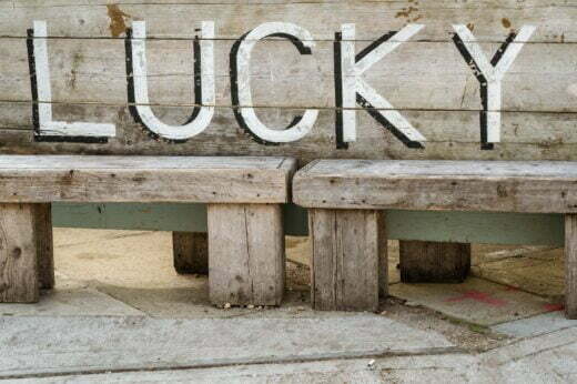 a wooden bench with the word lucky written on it