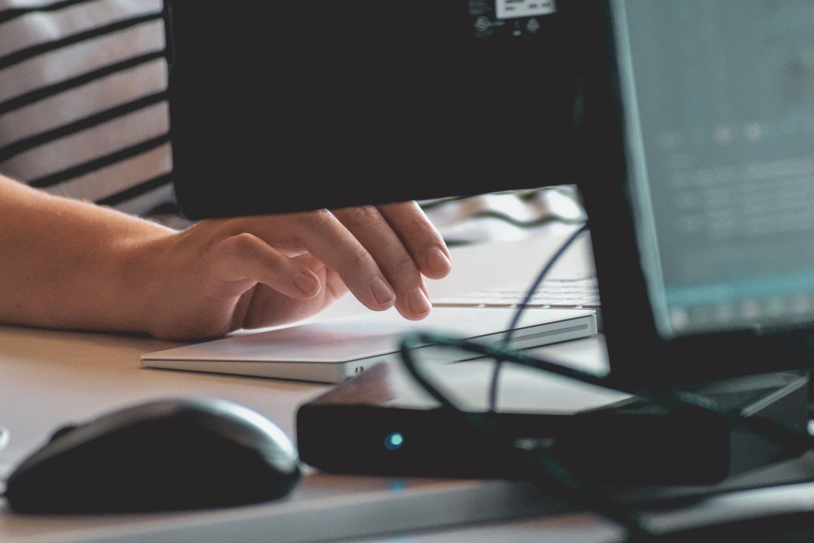 Pros and Cons of Using Cloud Computing for Software Development person using computer on table