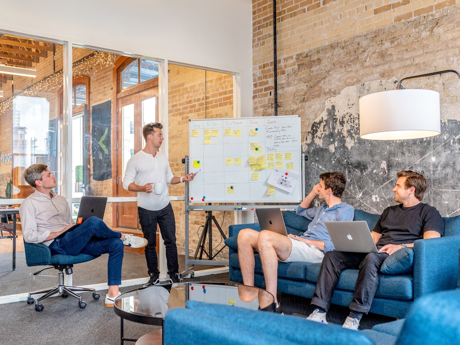 5 Ways To Stand Out As An Employee in Your Organization three men sitting while using laptops and watching man beside whiteboard