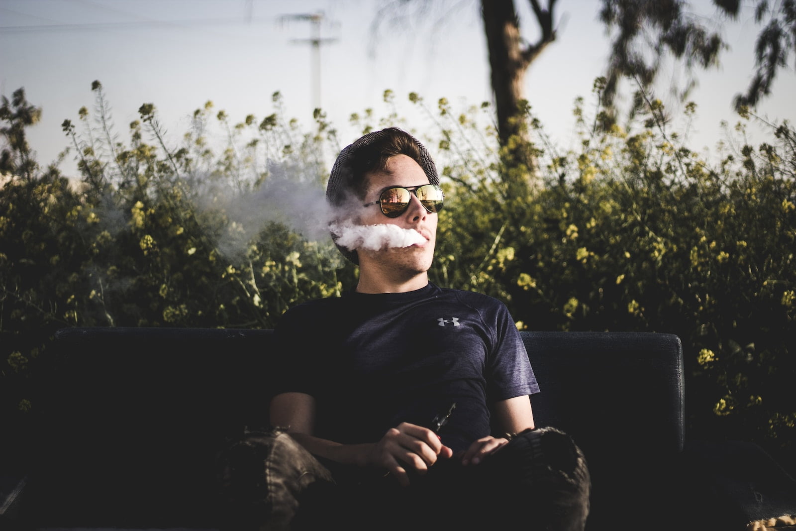 Pods and Puffs: Navigating the Vape Pod Revolution for a Healthier Option man sitting on bench and smoking