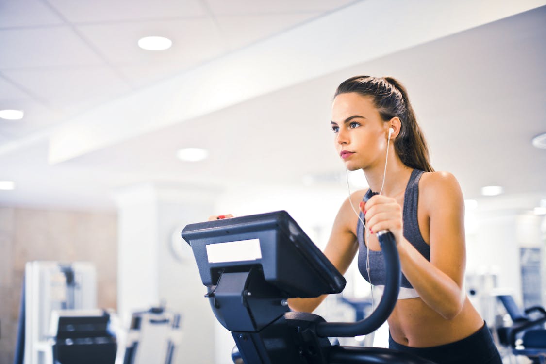 6 Tips for Individuals Struggling to Lose Weight Free Serious fit woman in earphones and activewear listening to music and running on treadmill in light contemporary sports center Stock Photo
