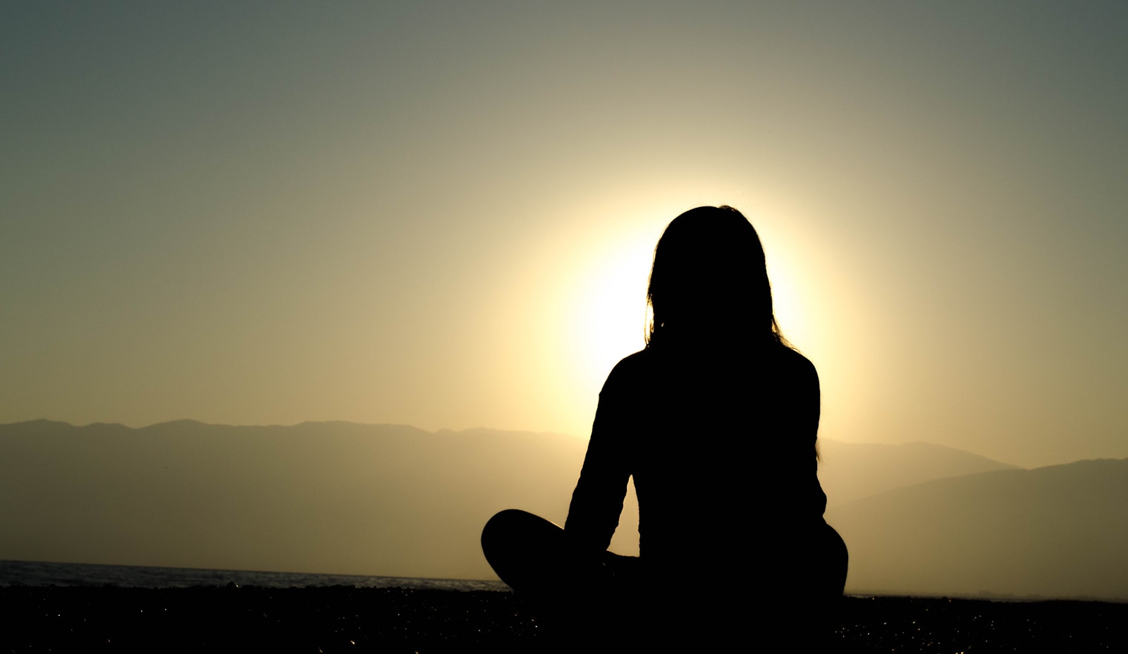 How Mindful Practices Can Transform Addiction Recovery woman sitting on sand