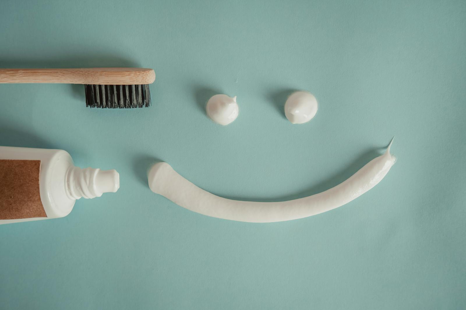 6 Preventive Treatments That Support Oral Health Year Round A playful arrangement of toothpaste and toothbrush forming a smile on a blue background.
