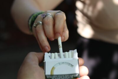 Hand with rings taking a cigarette from a pack