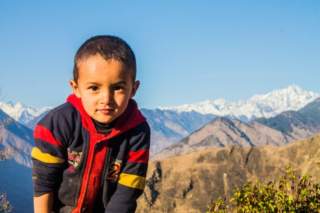 Young boy in front of snowy mountains